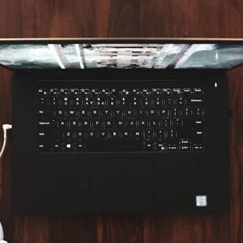 second hand laptop - black and gray laptop computer turned on on wooden surface