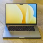 best laptop under 15000 - a laptop computer sitting on top of a wooden table