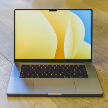 best laptop under 15000 - a laptop computer sitting on top of a wooden table