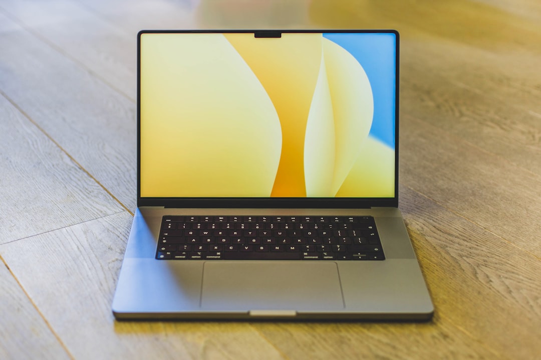 best laptop under 15000 - a laptop computer sitting on top of a wooden table