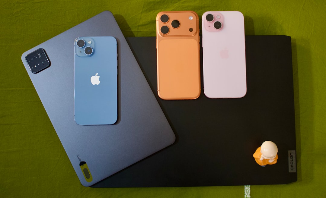 laptop for work from home india - Three iphones and a tablet on a green surface.