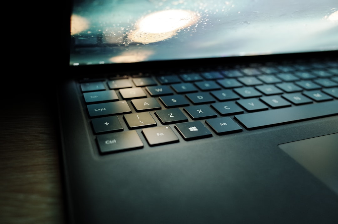 how to fix slow laptop - A laptop computer sitting on top of a wooden table