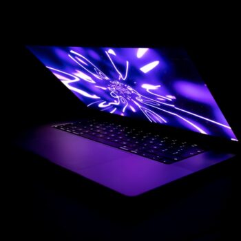 refurbished gaming laptops - a laptop computer with a glowing screen in the dark