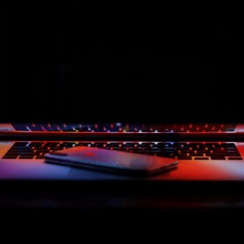 laptop buying checklist india - silver iPhone X on a slightly closed MacBook Pro keyboard