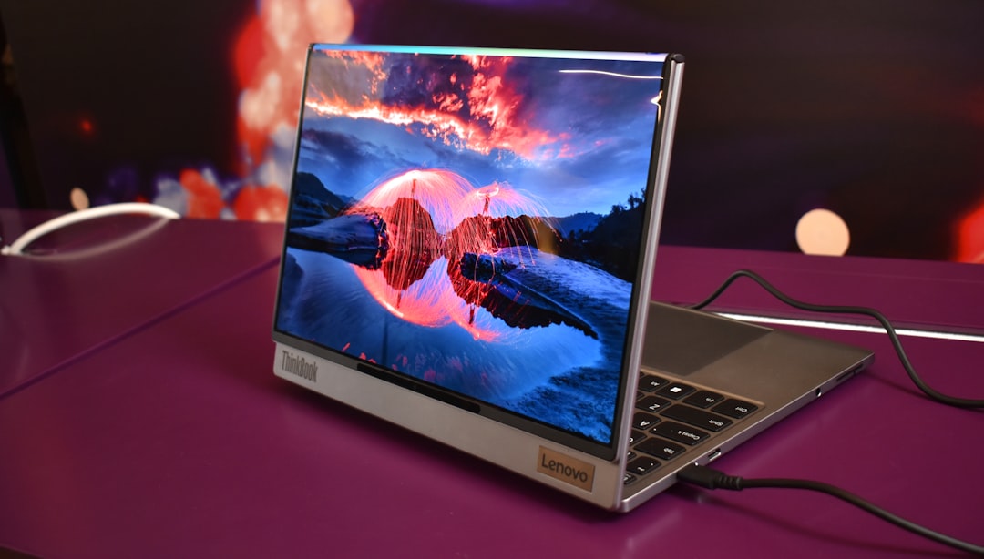 second hand lenovo laptop - Modern laptop displaying a vibrant landscape on screen.