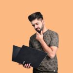 laptop under 25000 - a man holding a laptop