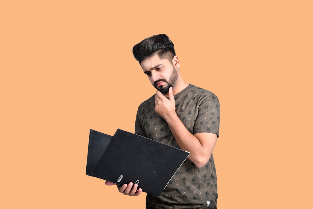 laptop under 25000 - a man holding a laptop