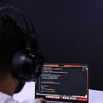 a man wearing headphones and using a laptop