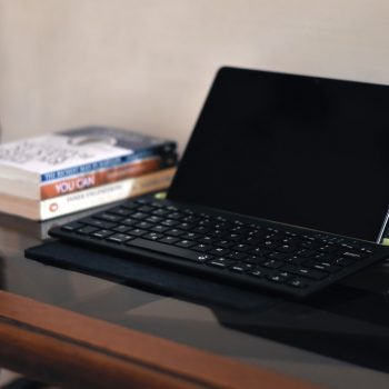 a laptop computer sitting on top of a wooden table